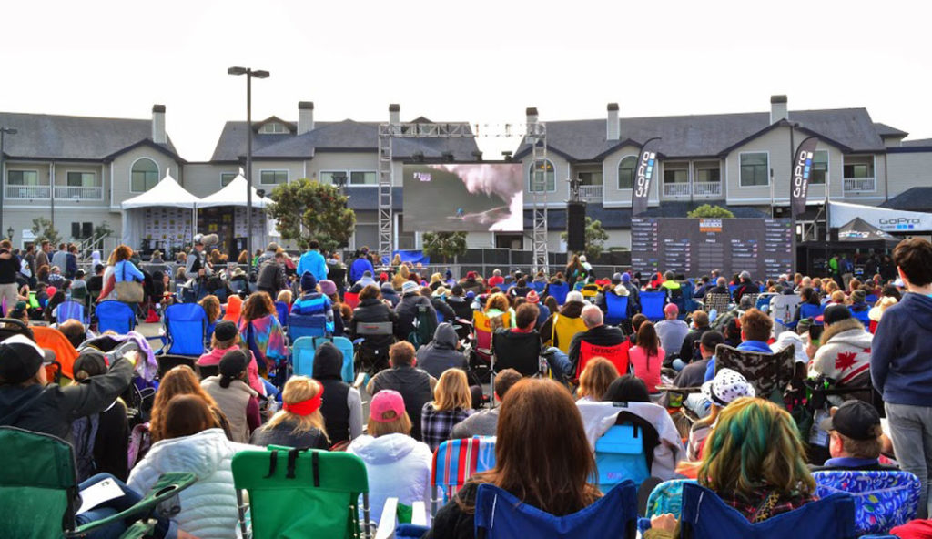 The crowd watches the event on the Jumbotron in the parking lot of the Oceano Hotel, as the cliffs prevent large crowds from watching at Pillar Point. Photo courtesy of Derrick Thompson.