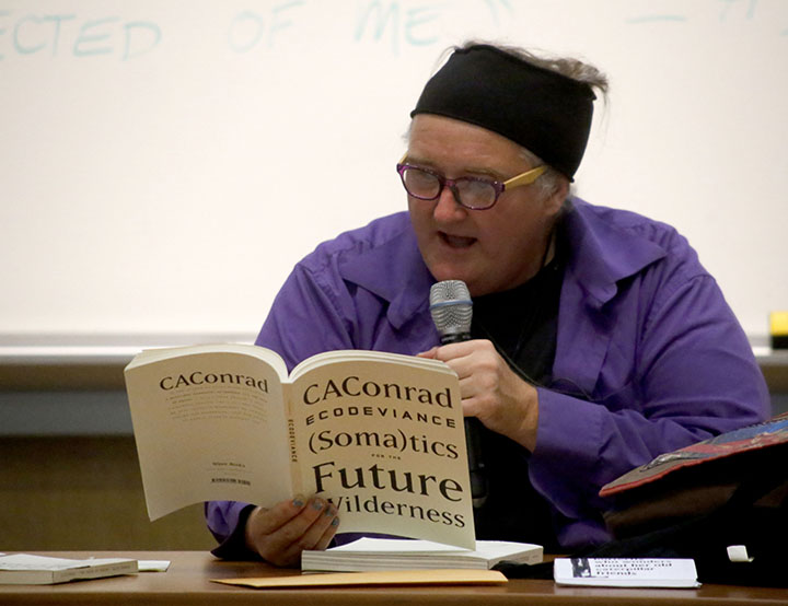 Poet CAConrad reads one of their book of poems to the audience last Thursday night for the first Living Writers Series of the school year. Photo by Calyse Tobias.